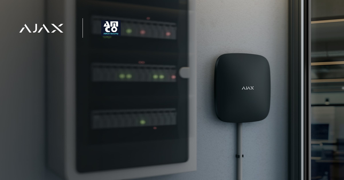 Ajax hub mounted on a wall beside an existing equipment cabinet